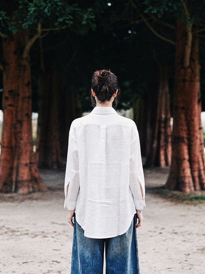 Back view of the white oversized shirt, showing the yoke seam, dropped shoulders and curved hem