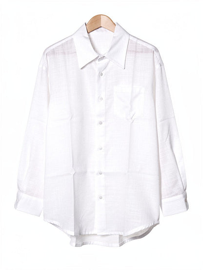 White oversized shirt in a textured slub weave on a hanger, front view with the chest pocket and curved shirttail hem