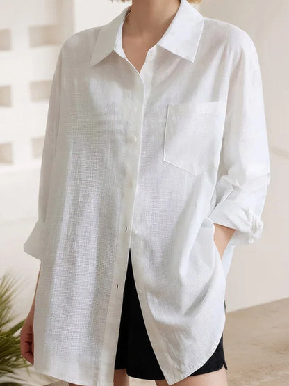 White oversized shirt in a textured slub weave, with a chest pocket and a curved shirttail hem, full length view