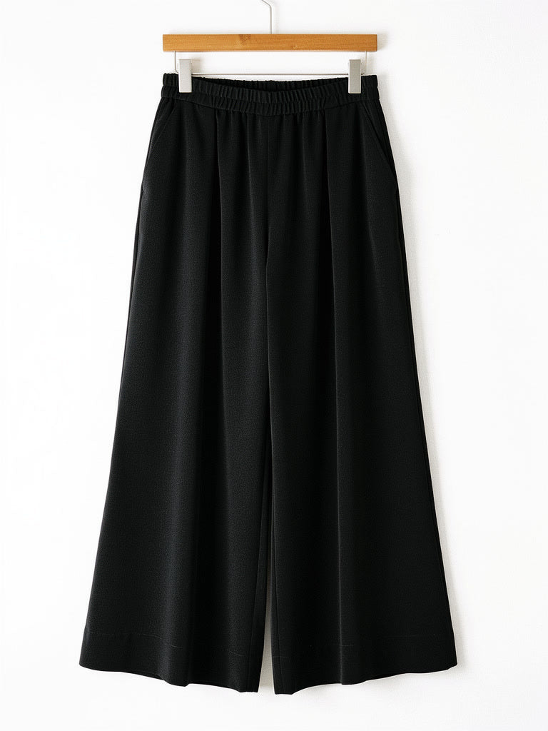 Black palazzo trousers on a hanger, pull on elasticated waist and wide leg