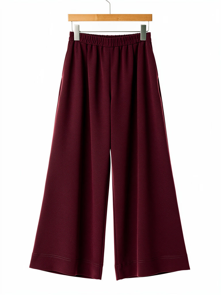Claret palazzo trousers on a hanger, showing the gathered elasticated waistband and wide leg