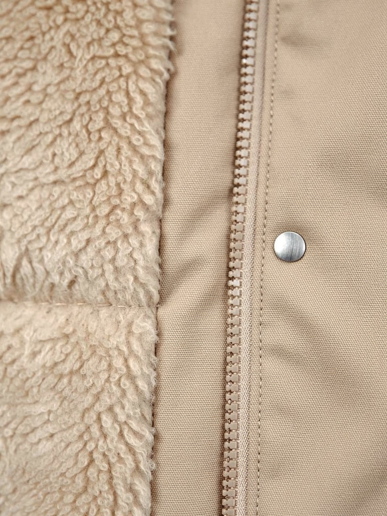 Close up of the deep borg fleece lining against the smooth unquilted shell of the parka coat