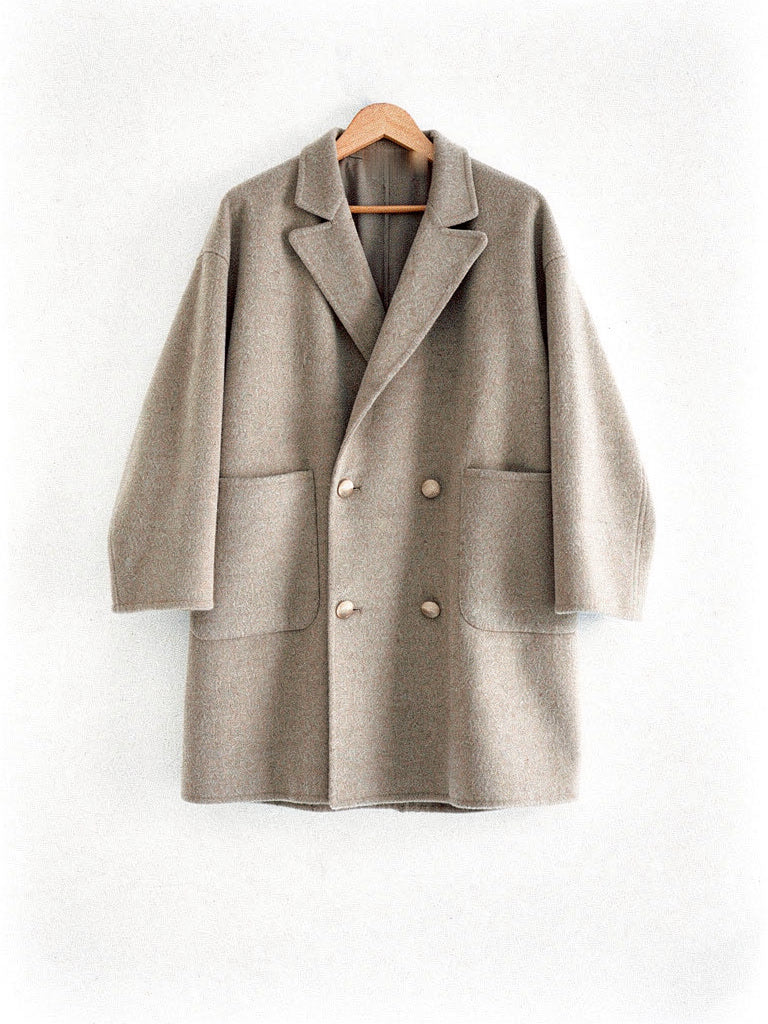Double breasted wool pea coat in Barley warm greige on a hanger, front view