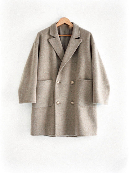 Double breasted wool pea coat in Barley warm greige on a hanger, front view