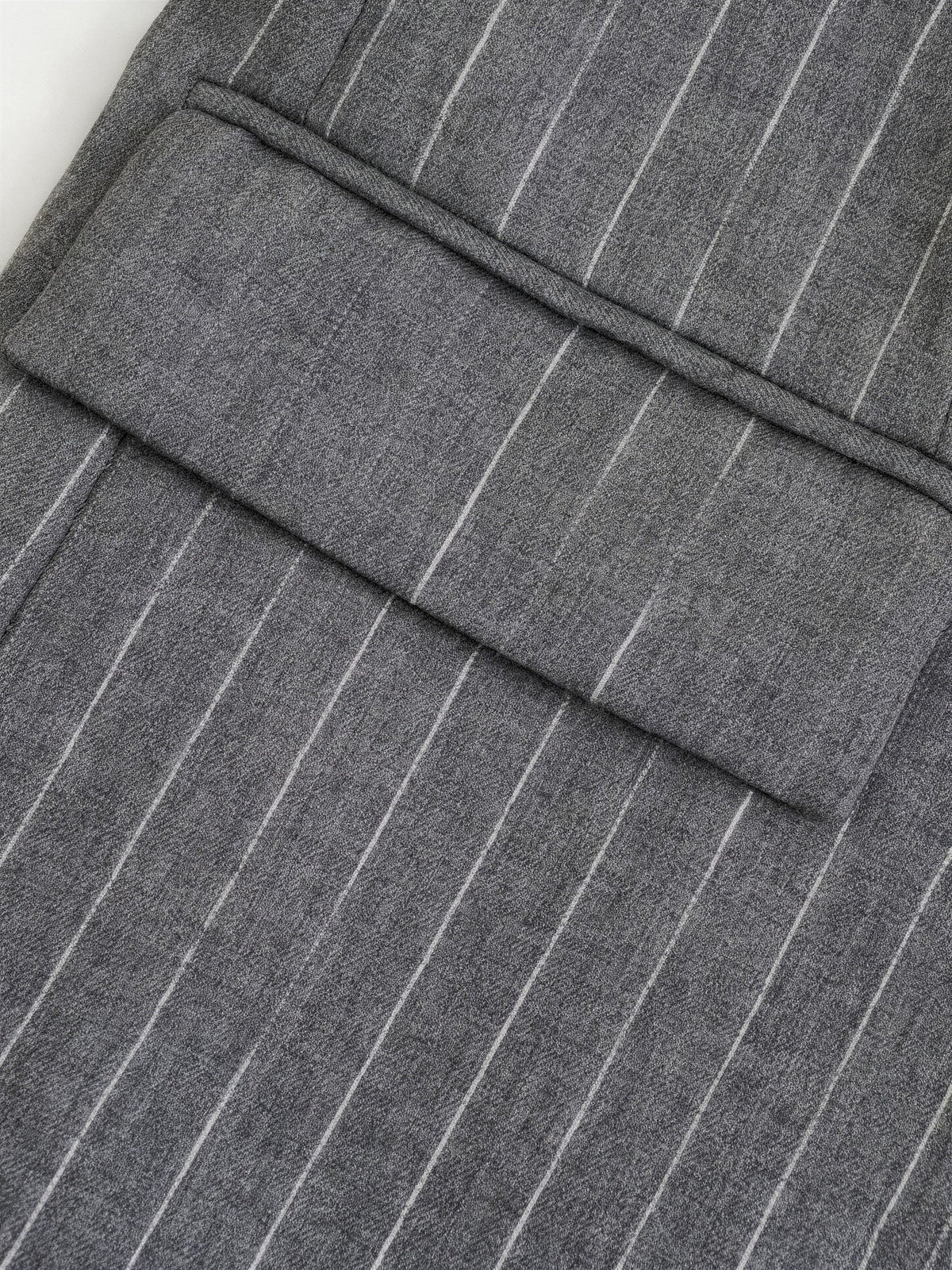 Close up of the chalk stripe suiting and hip flap pocket of the pinstripe blazer