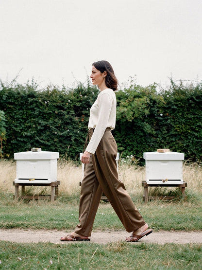 Nutmeg pleated trousers with a barrel leg worn walking