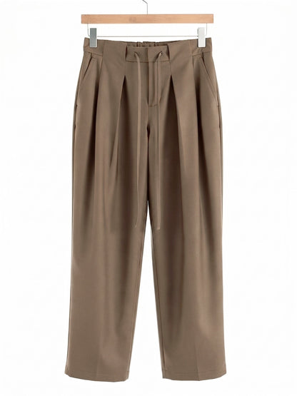 Nutmeg pleated trousers on a hanger, front view