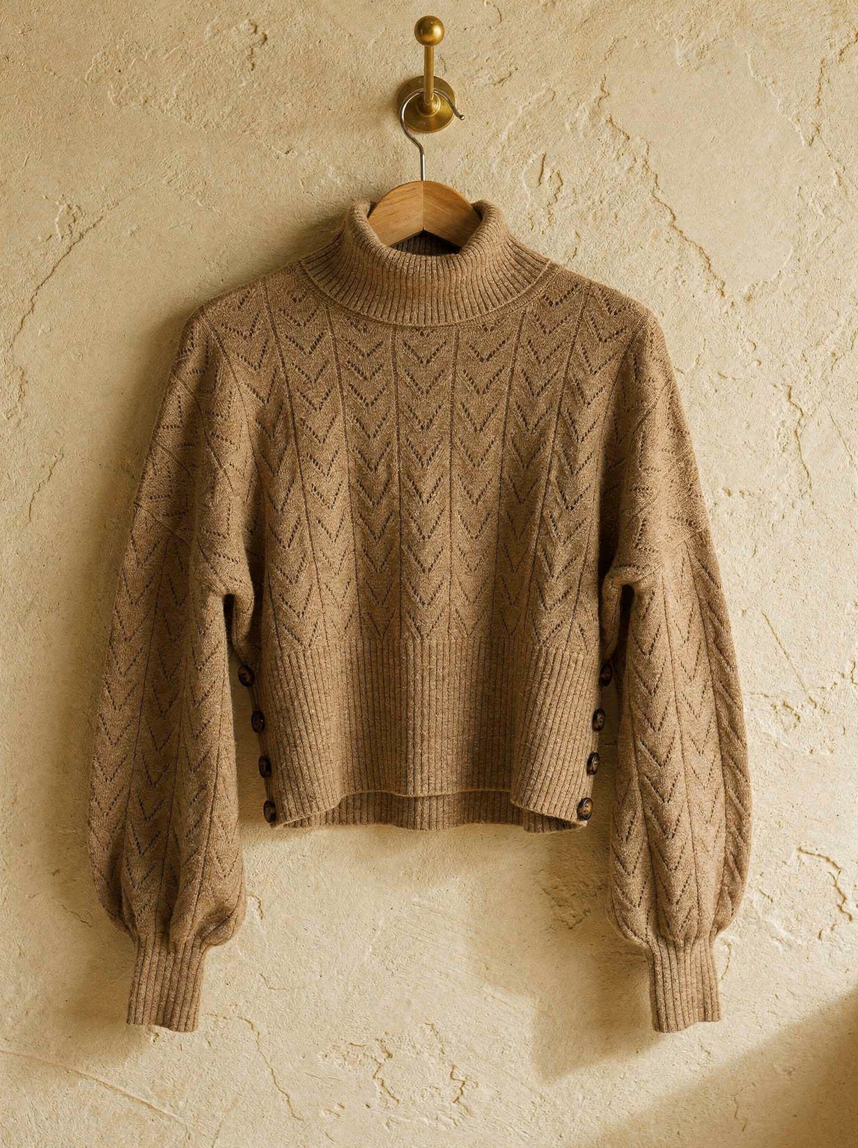 Camel pointelle roll neck jumper with batwing sleeves and buttoned ribbed waistband, on a hanger