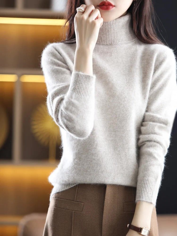 Limewash polo neck jumper worn with wool trousers, showing the tall roll neck, the deep ribbed cuffs and the ribbed hem
