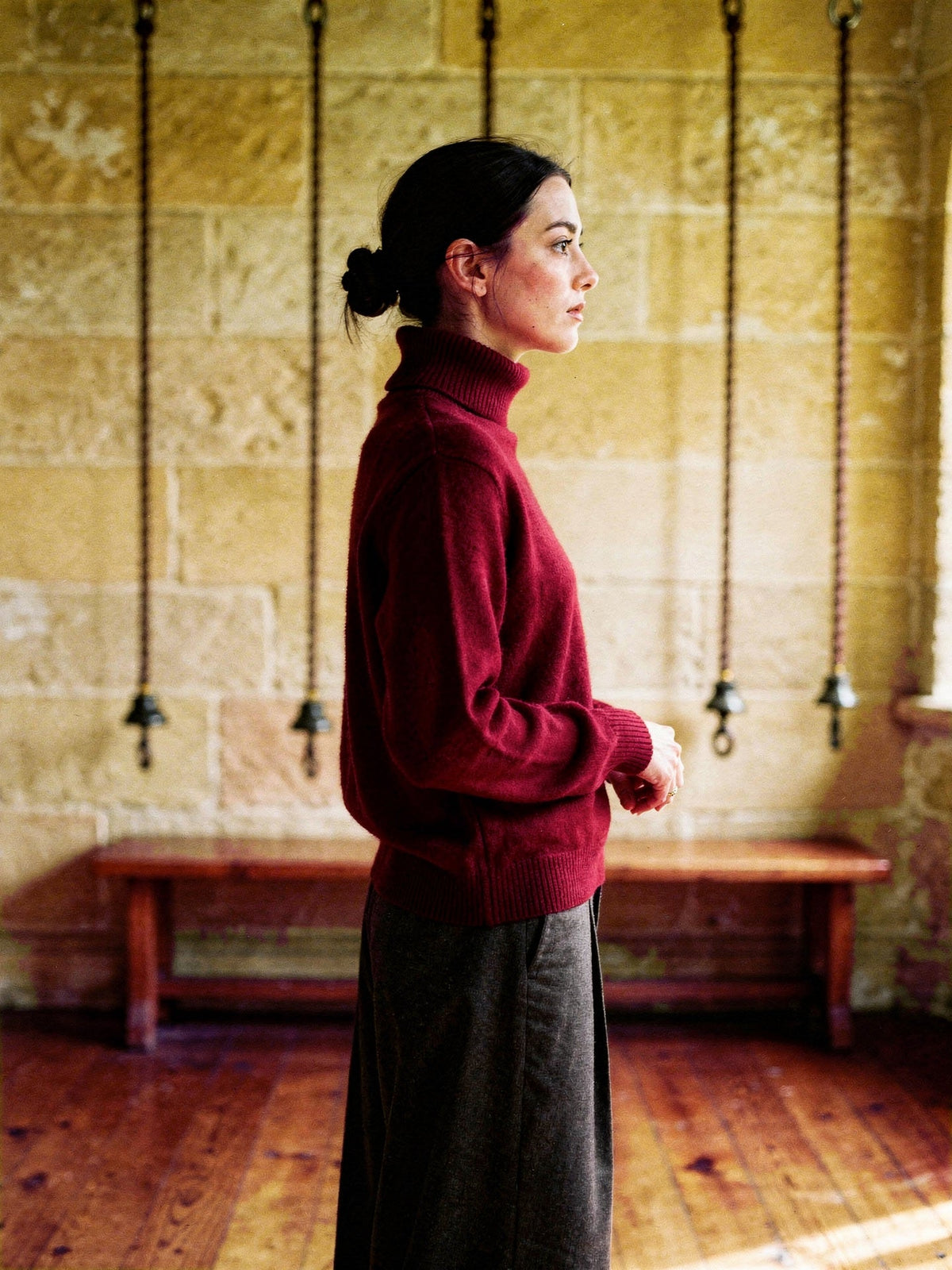 Madder polo neck jumper worn in a village church bell ringing chamber, showing the tall roll neck and the deep ribbed cuffs