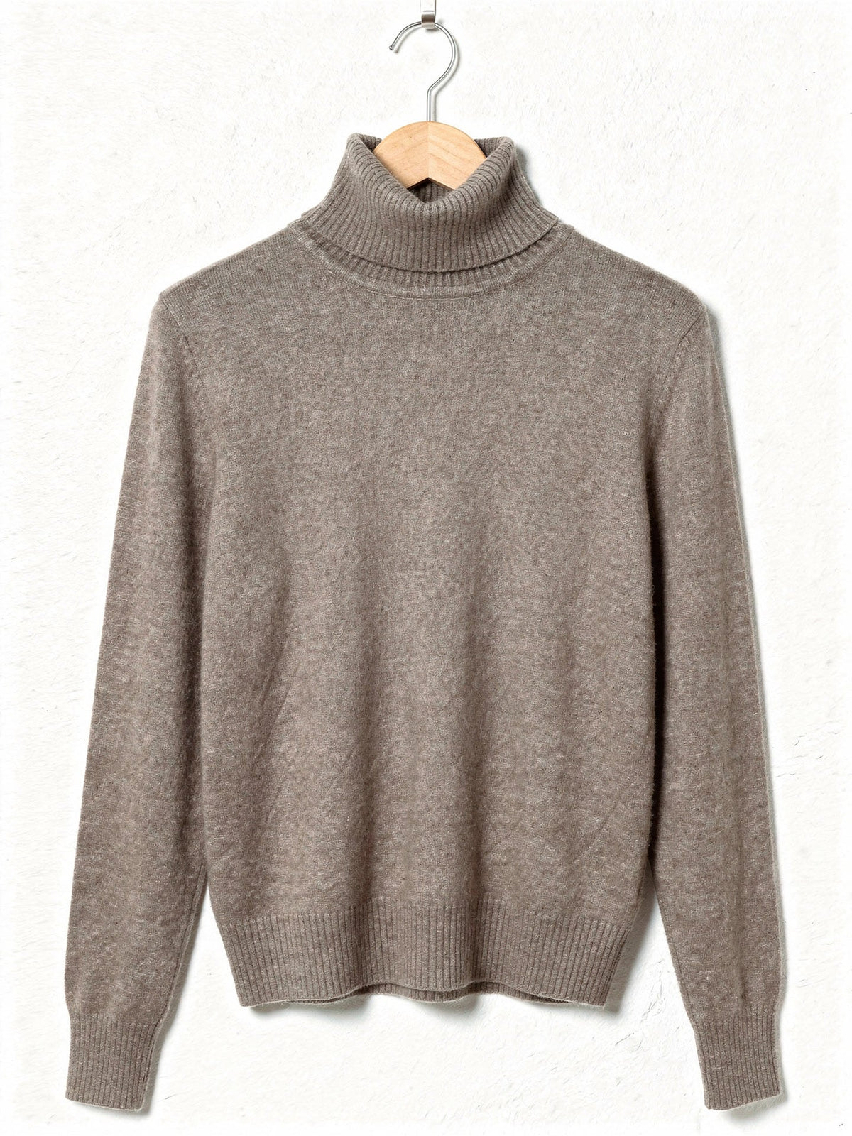 Teasel polo neck jumper on a hanger, showing the tall folded roll neck, the deep ribbed cuffs and the smooth brushed knit