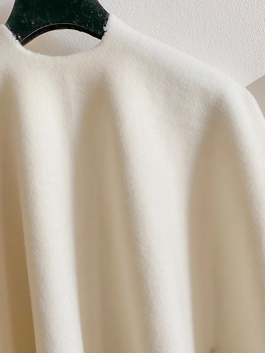 Back of the poncho cape in Muslin, showing the continuous back panel and the brushed cloth