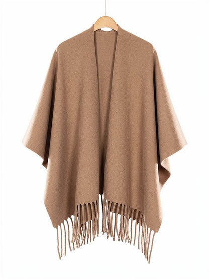 Open-front poncho cape in Hazel on a wooden hanger, showing the split front and the fringed hem