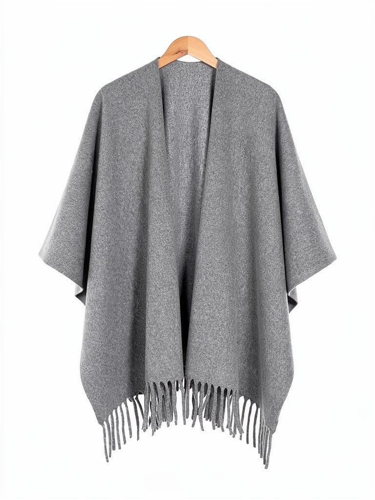 Open-front poncho cape in Smoke on a wooden hanger, showing the fringed hem