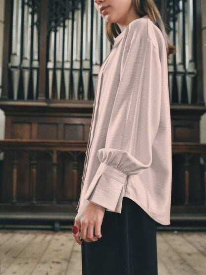 Powder pink blouse worn loose, showing the gathered sleeve band and deep fluted cuff