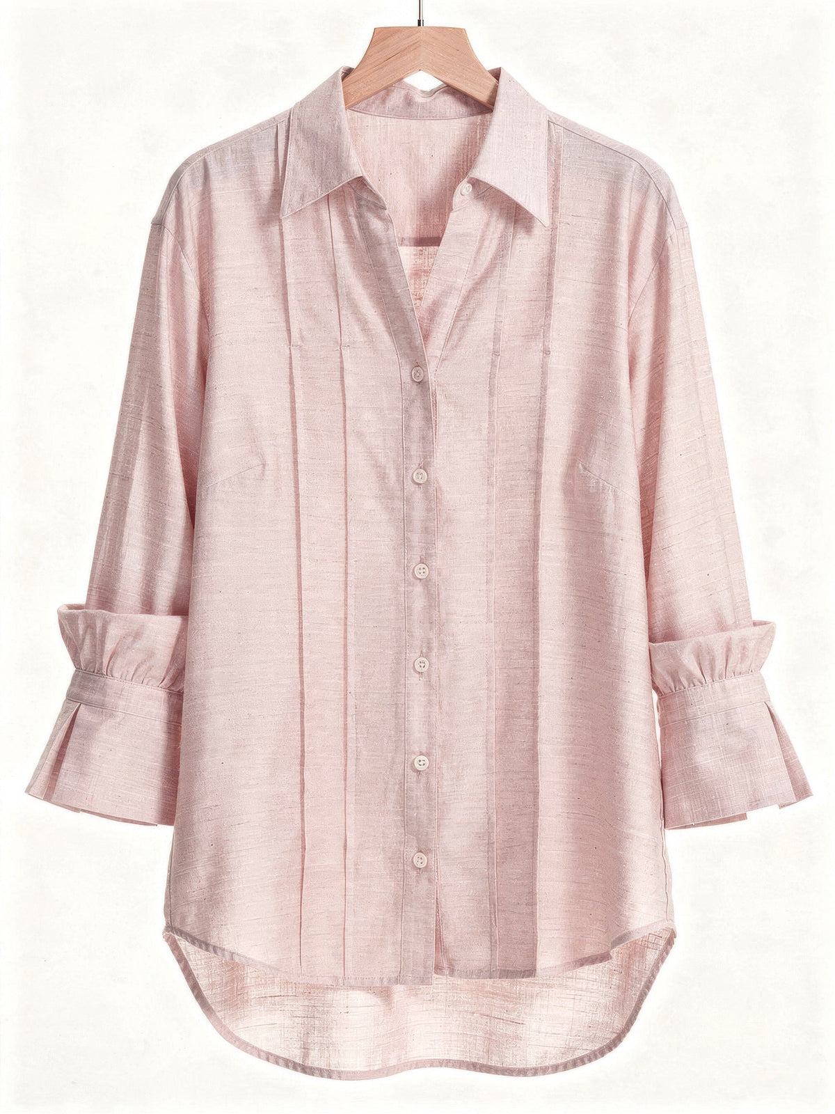 Powder pink blouse on a wooden hanger with a pintuck front and deep fluted cuffs