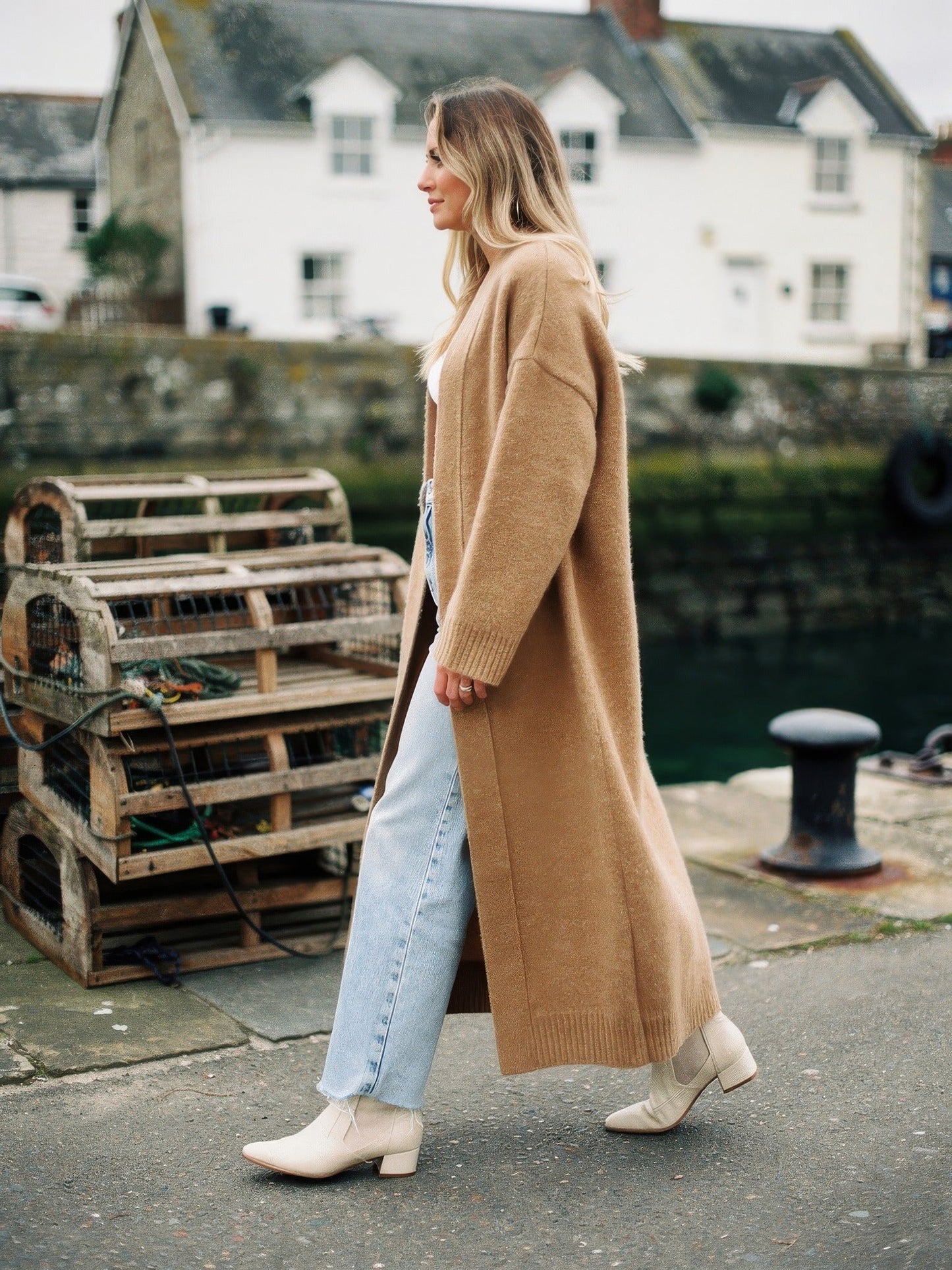 Praline chunky knit coatigan worn open on a harbour quay