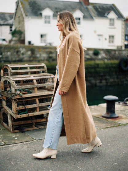 Praline chunky knit coatigan worn open on a harbour quay