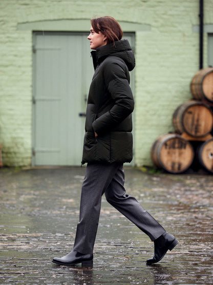 Puffer jacket in Jet Black, side view walking across a cobbled yard