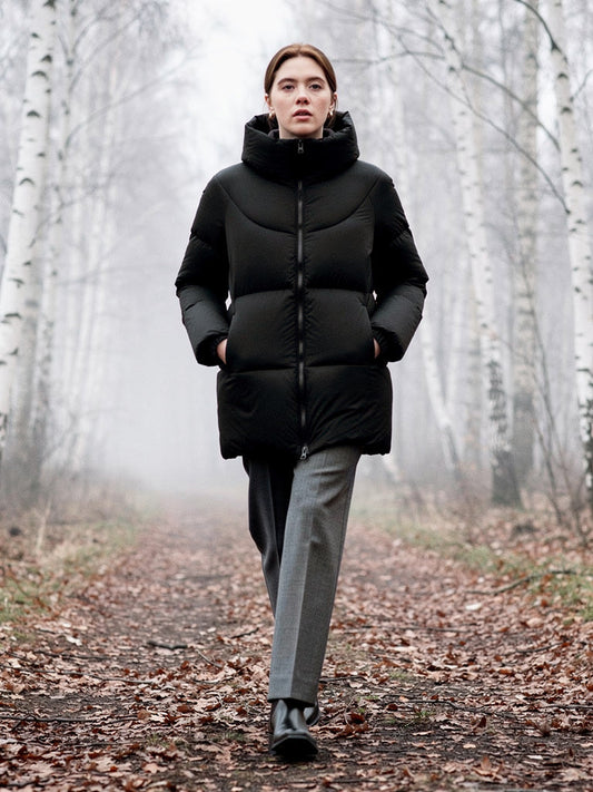 Womens puffer jacket in Jet Black, worn on a path through a winter birch wood