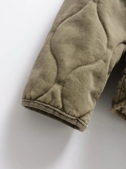 Fleece lining visible at the cuff of the olive quilted jacket