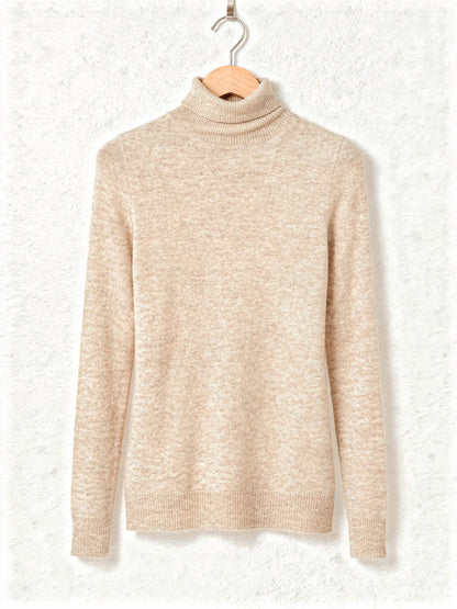 Roll neck jumper in Barley, a warm cream fine knit, on a wooden hanger
