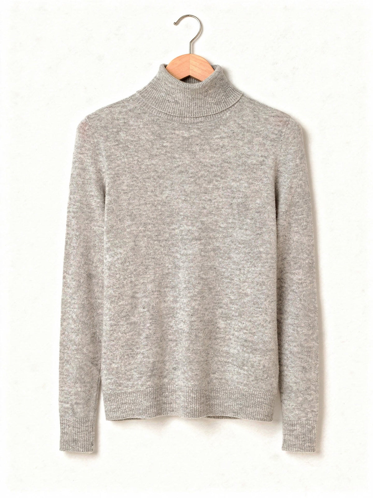 Roll neck jumper in Birch Marl, a pale heathered grey fine knit, on a wooden hanger