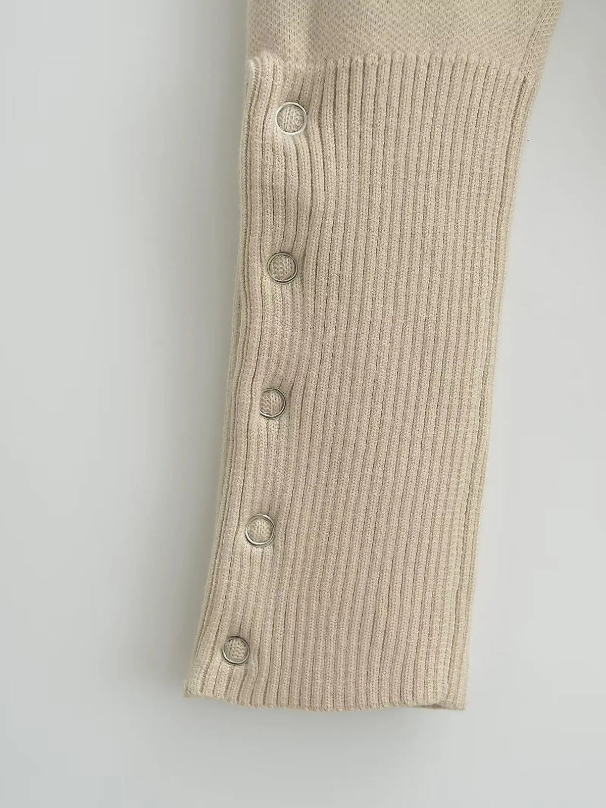Deep ribbed cuff of the cropped cardigan with five silver press studs