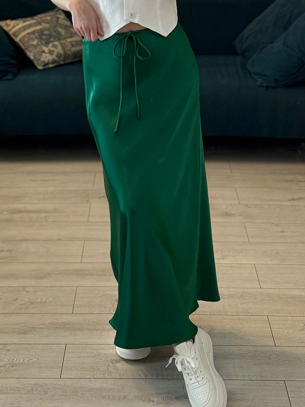 Emerald green satin maxi skirt worn with trainers, drawstring waist detail
