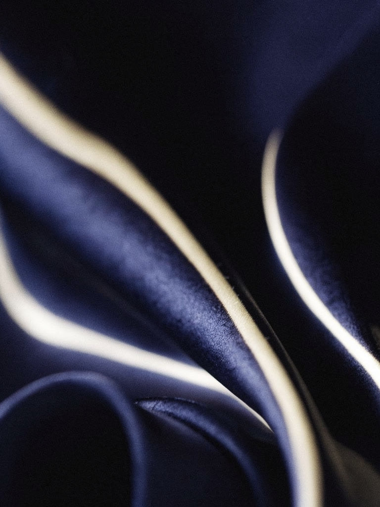 Close up of the fluid navy satin of the shirt showing its soft shine