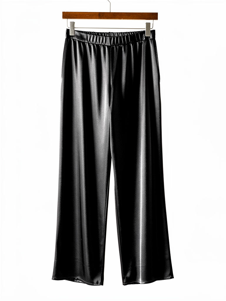 Black satin trousers on a hanger, elasticated pull on waistband and wide straight leg