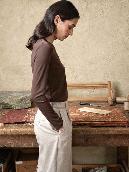 Side view of the slim chocolate silk blend top worn in a bookbinding workshop