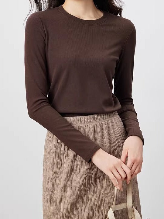 Chocolate silk blend top with a ribbed crew neck and long sleeves, worn with a stone pleated skirt