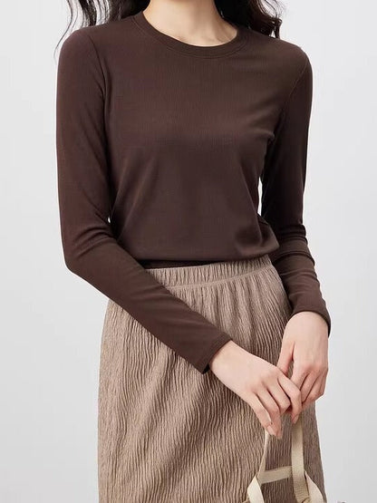 Chocolate silk blend top with a ribbed crew neck and long sleeves, worn with a stone pleated skirt