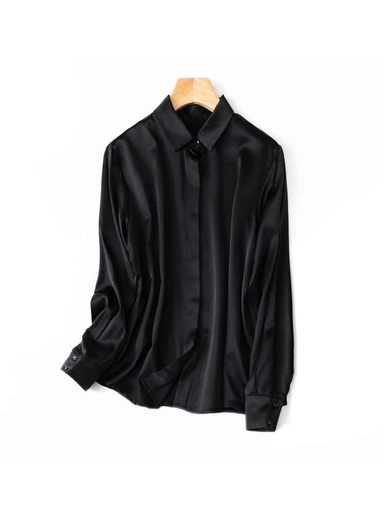Black silk shirt photographed on a hanger against a white background
