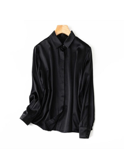 Black silk shirt photographed on a hanger against a white background