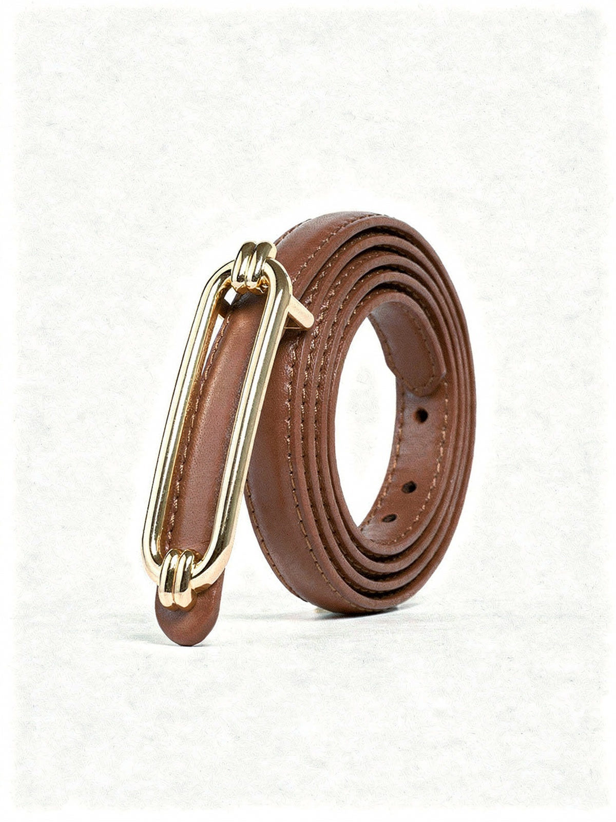 Skinny belt in Cedar cow leather, coiled, with its polished gold oblong buckle