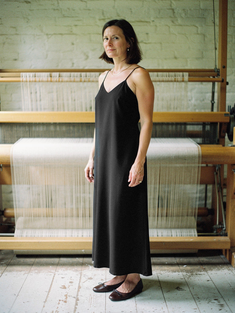 Black slip dress worn in a weaving workshop, strappy V neck ankle length A line