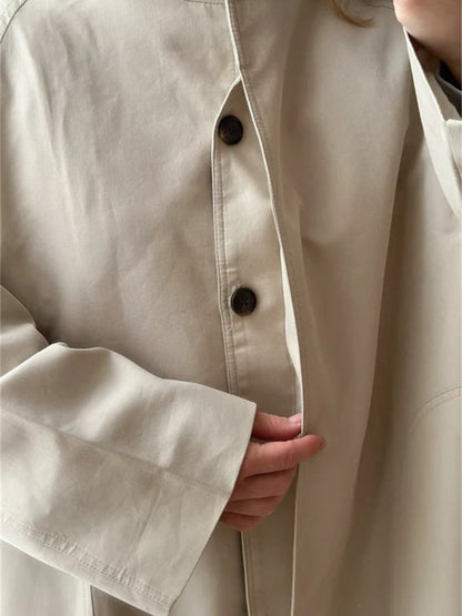 Detail of the standing band collar, the tonal buttons and the deep turn back cuff of the stand collar coat