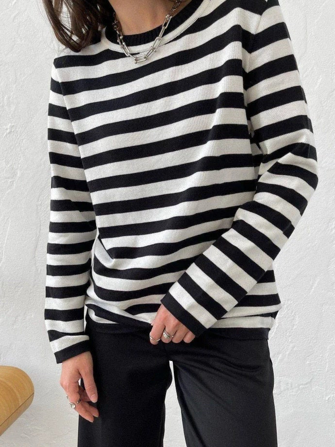 Black striped jumper worn with black trousers, full length