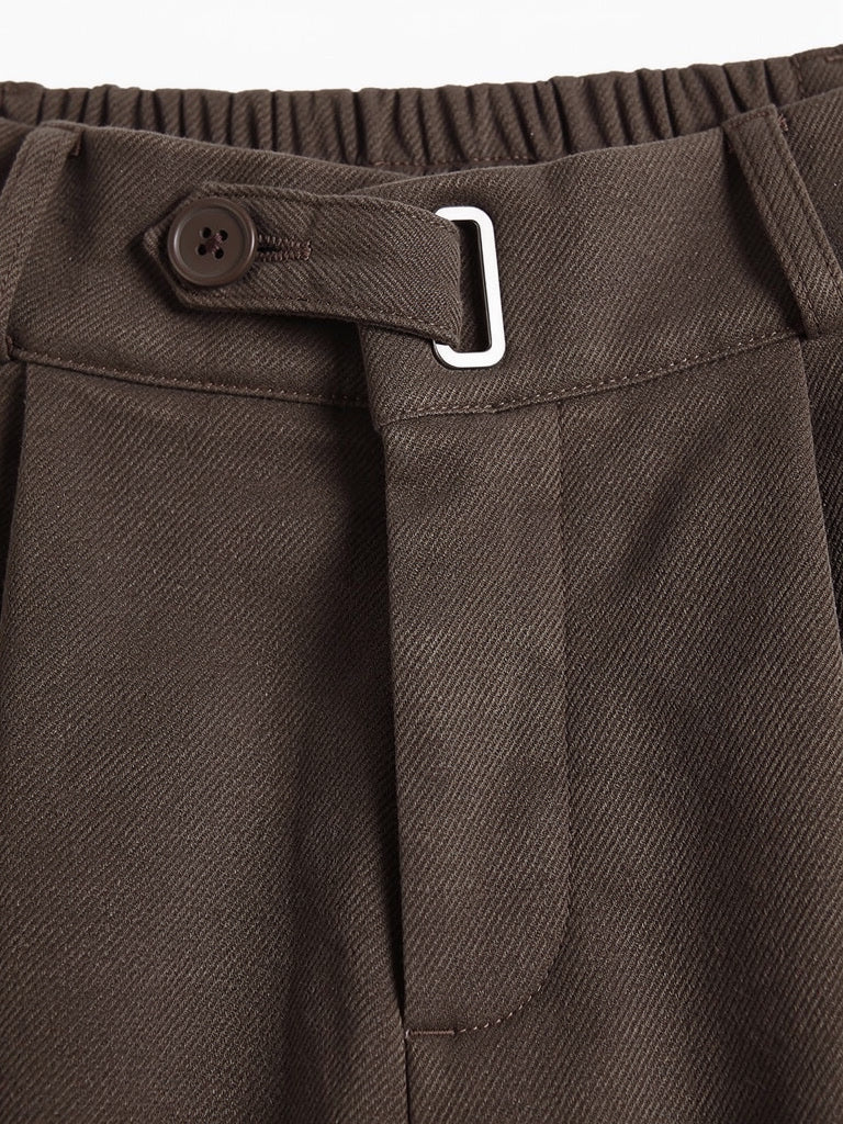 Close-up of the brushed twill weave, waistband tab and metal loop on the tailored trousers