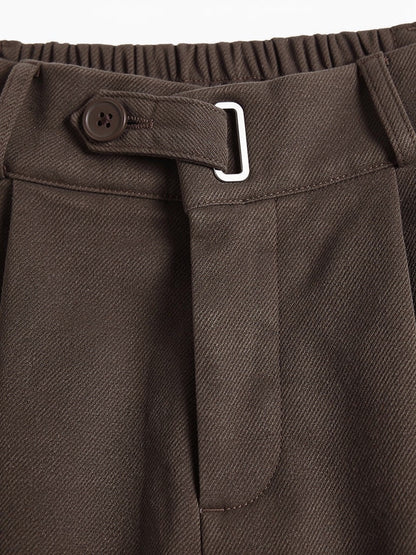 Close-up of the brushed twill weave, waistband tab and metal loop on the tailored trousers