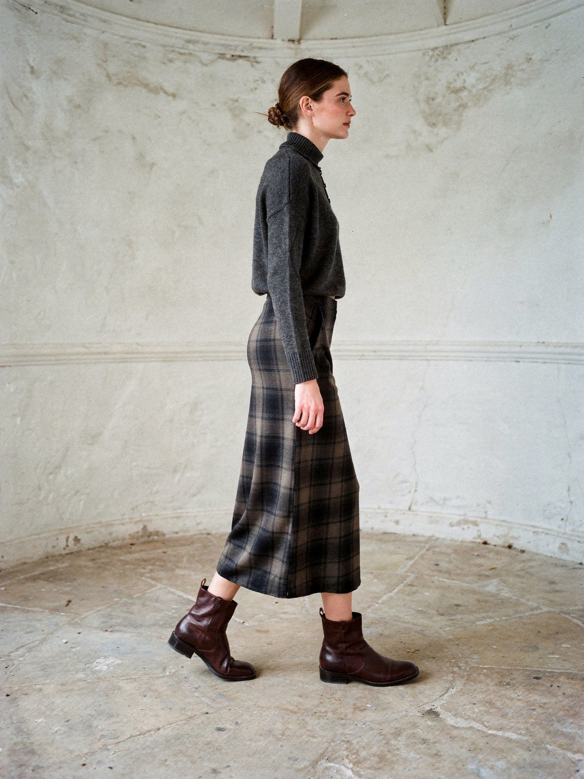 Tartan midi skirt worn walking, the checked A-line panels swinging with the step
