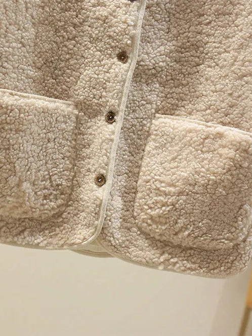 Close up of the patch pockets and horn effect buttons on the teddy gilet