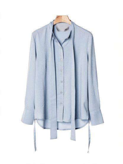 Powder blue tie-waist blouse on a hanger, front view, open collar and button through placket