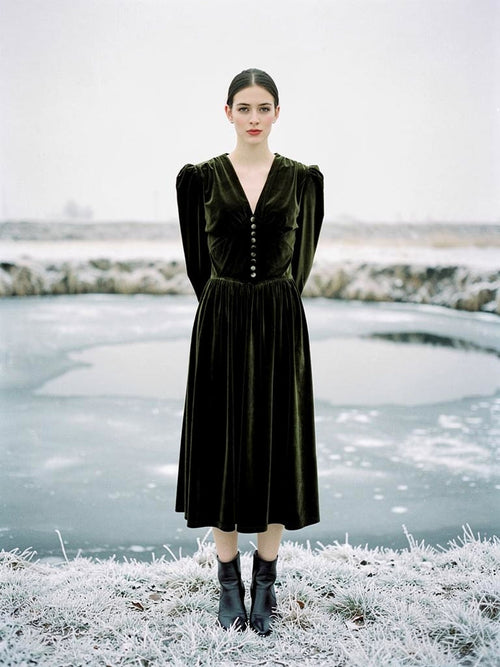 Velvet midi dress in Loden Green, worn by a frozen park pond in winter