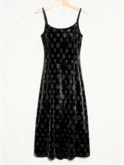 Velvet slip dress in black shown from the front on a plain wooden hanger