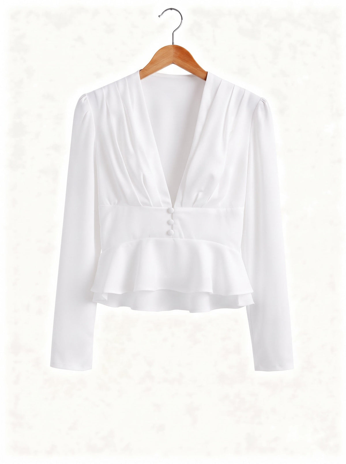 White peplum blouse on a hanger showing the deep V neck and the double peplum frill