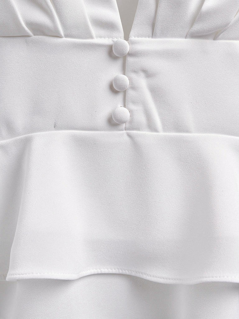 Close up of the waist of the white peplum blouse with its three covered buttons and double frill