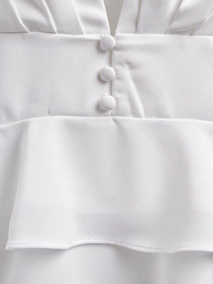 Close up of the waist of the white peplum blouse with its three covered buttons and double frill